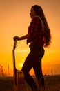 Silhouette of young girl with guitar at sunset Royalty Free Stock Photo