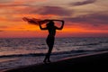 Silhouette of young girl, jumping with silk cloth against of sea sunset Royalty Free Stock Photo