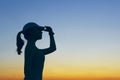 Silhouette of young girl over sunset sky background.  People, travel, nature concept. Royalty Free Stock Photo