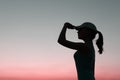 Silhouette of young girl over sunset sky background.  People, travel, nature concept. Royalty Free Stock Photo