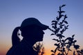 Silhouette of young girl over sunset sky background.  People, travel, nature concept. Royalty Free Stock Photo