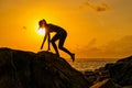 Silhouette young girl runs along the rocks by the sea at dawn on a tropical island Royalty Free Stock Photo