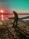 Silhouette of a young girl at sunset on the background of the river with bike, summer and sports Royalty Free Stock Photo