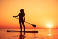 Silhouette of young girl walking on sup board