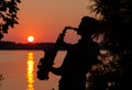 Silhouette of a young guy playing the saxophone in the evening at sunset Royalty Free Stock Photo