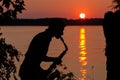 Silhouette of a young guy playing the saxophone in the evening at sunset Royalty Free Stock Photo