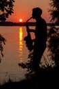 Silhouette of a young guy playing the saxophone in the evening at sunset Royalty Free Stock Photo