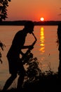 Silhouette of a young guy playing the saxophone in the evening at sunset Royalty Free Stock Photo