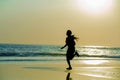 Silhouette of young happy and attractive African American runner woman exercising in running fitness sprint workout at beautiful b Royalty Free Stock Photo