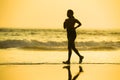 Silhouette of young happy and attractive African American runner woman exercising in running fitness workout at beautiful beach jo Royalty Free Stock Photo