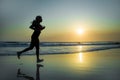 Silhouette of young happy and attractive African American runner woman exercising in running fitness workout at beautiful beach jo Royalty Free Stock Photo