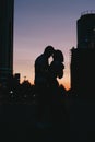 Silhouette of young happy couple in love kissing on city street at sunset Royalty Free Stock Photo