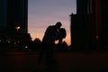 Silhouette of young happy couple in love kissing on city street at sunset Royalty Free Stock Photo