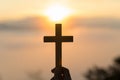Silhouette of young human hands praying with a cross at sunrise, Christian Religion concept background Royalty Free Stock Photo