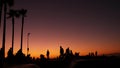 Silhouette of young jumping skateboarder riding longboard, summer sunset background. Venice Ocean Beach skatepark, Los Angeles