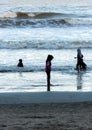 Silhouette of young kids playing at the beach during sunset