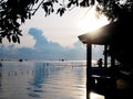 Silhouette of young lady photographer at pavilion beside the sea Royalty Free Stock Photo