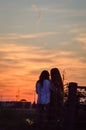 Silhouette of a young loving couple kissing at sunset, in the countryside Royalty Free Stock Photo