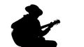 Silhouette of young male in hat playing guitar at party, cool hobby, recreation Royalty Free Stock Photo