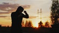 Silhouette of young man boxer training for kicking on sunset at city park