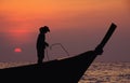 Silhouetted fisherman at sunset
