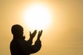 Silhouette of young man hands open palm up worship and praying to god at sunrise, Christian Religion concept background Royalty Free Stock Photo