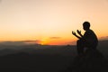 Silhouette of young  man hands open palm up worship and praying to god  at sunrise, Christian Religion concept background Royalty Free Stock Photo