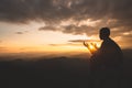 Silhouette of young  man hands open palm up worship and praying to god  at sunrise, Christian Religion concept background Royalty Free Stock Photo