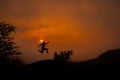 Silhouette of young man jumping against sunset with copy space. Royalty Free Stock Photo