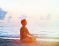 Silhouette of young man meditating at sunset Royalty Free Stock Photo