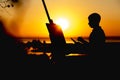 Silhouette of a young man painting a picture on linen on an easel outdoors, painter face profile engaged in art on nature in a fie