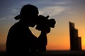 Silhouette young man photographer taking picture on the roof top with sunset sky scene Royalty Free Stock Photo