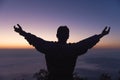 Silhouette of a young man praying to God on the mountain at sunset background.  raising his hands in worship. Christian Religion Royalty Free Stock Photo