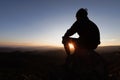 Silhouette of a young man praying to God on the mountain at sunset background. Woman raising his hands in worship. Christian Royalty Free Stock Photo