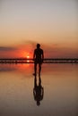 Silhouette of young man by the sea at sunset walking and enjoying freedom and life on summer holiday vacation. Concept Royalty Free Stock Photo