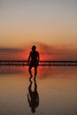 Silhouette of young man by the sea at sunset walking and enjoying freedom and life on summer holiday vacation. Concept Royalty Free Stock Photo