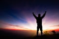 Silhouette of man standing on top of mountain with fists raised up, successful, achievement and winning concept Royalty Free Stock Photo
