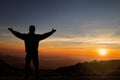 Silhouette of man standing on top of mountain with hands raised up on sunrise background, successful, achievement and winning Royalty Free Stock Photo