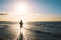 Silhouette of a young man standing on the seashore facing the sun. Outdoors, summer, freedom concept