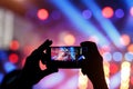 Silhouette of young man, taking photo rock concert on the mobile phone Royalty Free Stock Photo