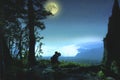 Silhouette of a young man who sits on the edge of the observation deck and enjoying night landscape with starry sky and full moon Royalty Free Stock Photo