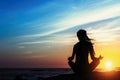 Silhouette young meditation woman practicing yoga on the beach.