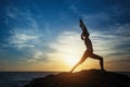 Silhouette young meditation woman practicing yoga on the ocean beach at amazing sunset. Royalty Free Stock Photo