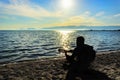 Silhouette.Young men playing guitar while sitting on the beach. Royalty Free Stock Photo