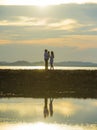 Silhouette of young romantic couple holding and playing with son or daughter little baby enjoying sunset having a walk at beach Royalty Free Stock Photo