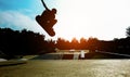 Silhouette of young skater jumping on ramp at city park - Boy performing tricks and skills with skateboard at sunset  - Youth Royalty Free Stock Photo