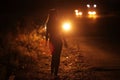 Silhouette of young slender woman in the backlight of car headlights on the road Royalty Free Stock Photo