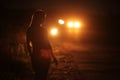 Silhouette of young slender woman in the backlight of car headlights on the road Royalty Free Stock Photo