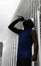 Silhouette of young sport man drinking water bottle after running training session in business district Royalty Free Stock Photo