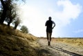 Silhouette of young sport man running on countryside in cross country workout at summer sunset Royalty Free Stock Photo